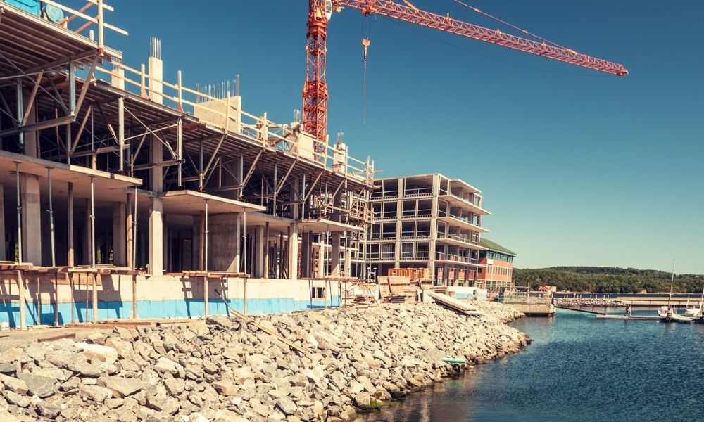 Waterfront redevelopment construction project beside a marina with commercial buildings under development