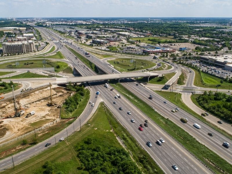 Aerial view of highway interchange expansion and roadway construction project with grading and traffic infrastructure