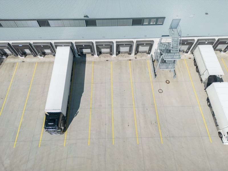 Aerial view of a commercial warehouse loading dock area in Fort Myers Florida showing truck access space and site conditions reviewed during a property survey